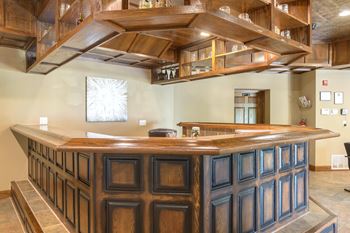 A wooden bar with a counter and a shelf above it.